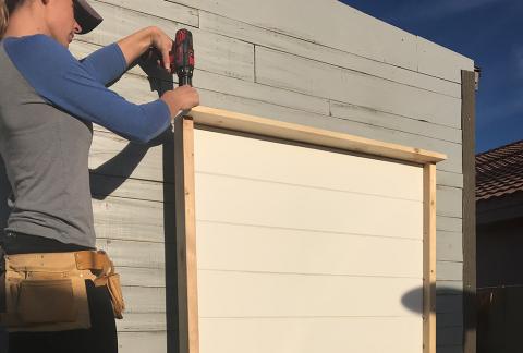 woman measuring stacked wood pieces