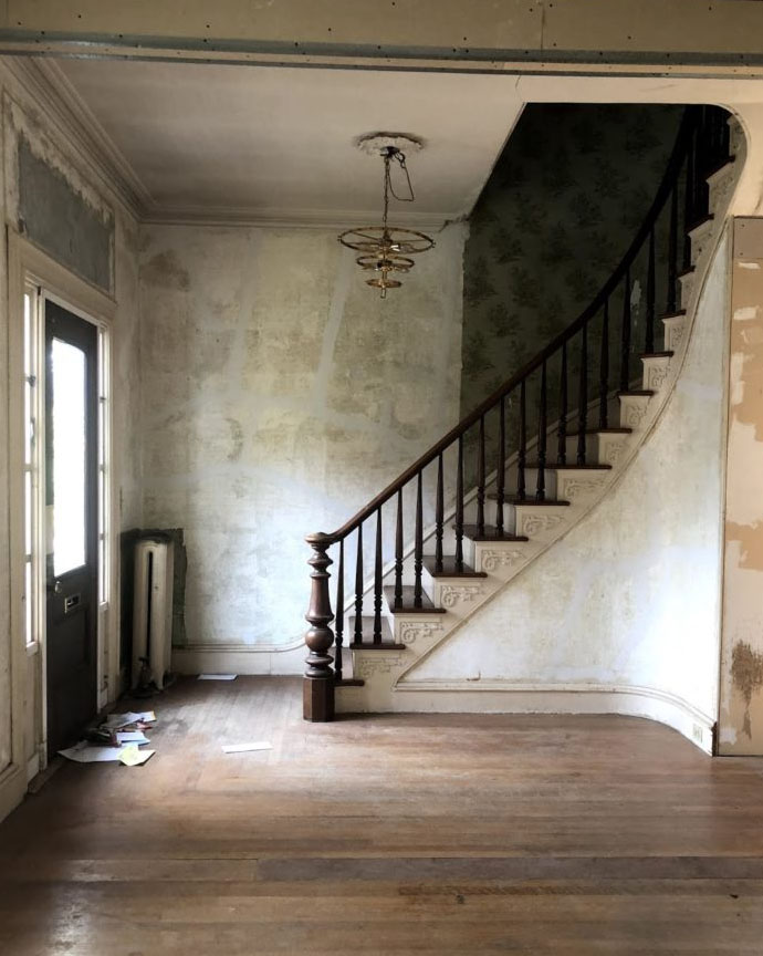 historic home descending staircase entryway with unfinished walls