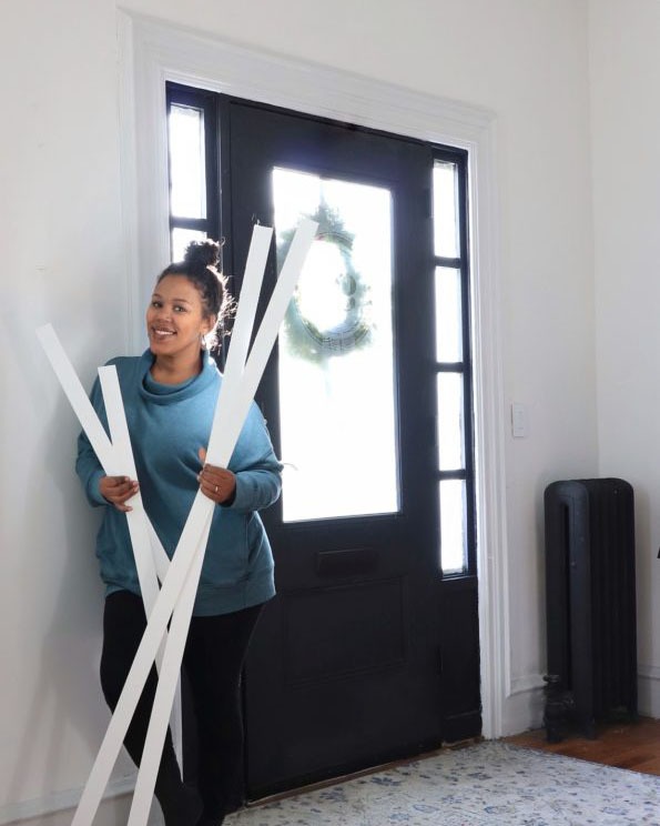 woman holding PVC trim posing by her front door