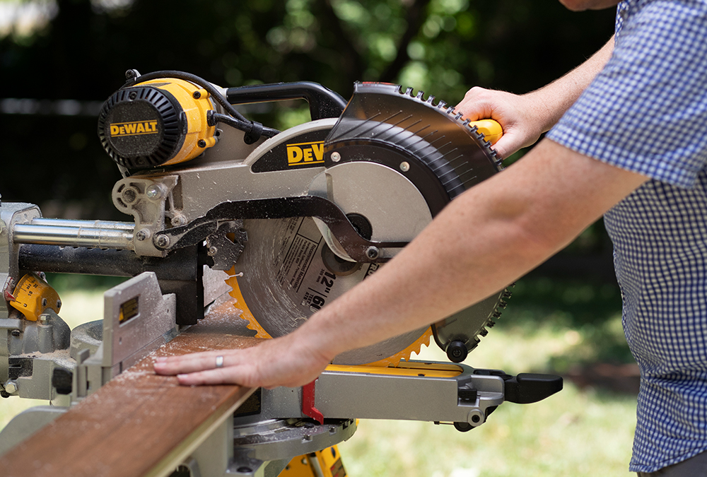 man sawing wood with a power saw